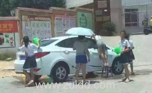 江西赣州章贡区水南小学一女老师撑伞指挥让学生在烈日下给自己洗车